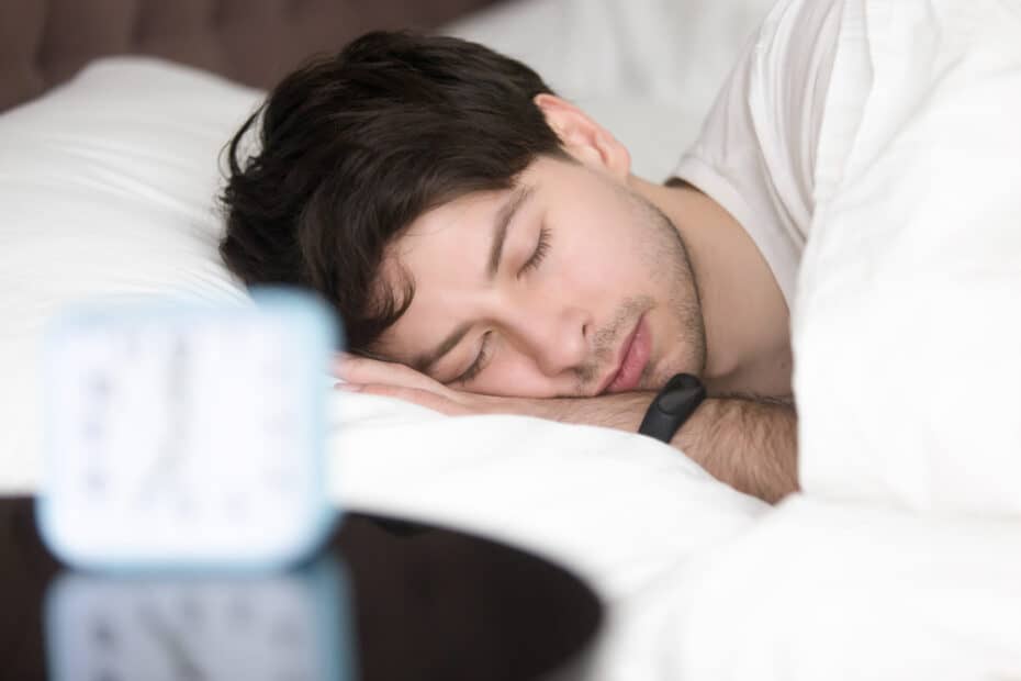 young man sleeping alarm clock wearing smart wristband