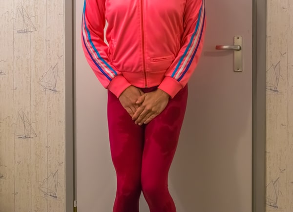 27930350 young women wetting her leggings and holding her hands in front of her crotch embarrassing accidents urinary incontinence medical issues