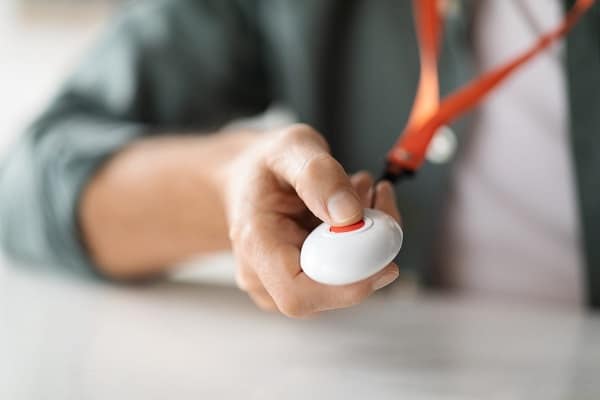 53139076 unrecognizable senior man pushing panic button on emergency equipment 1