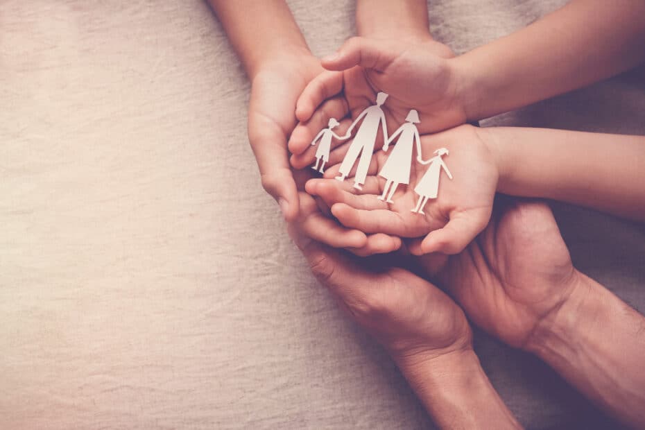 adult children hands holding paper family cutout