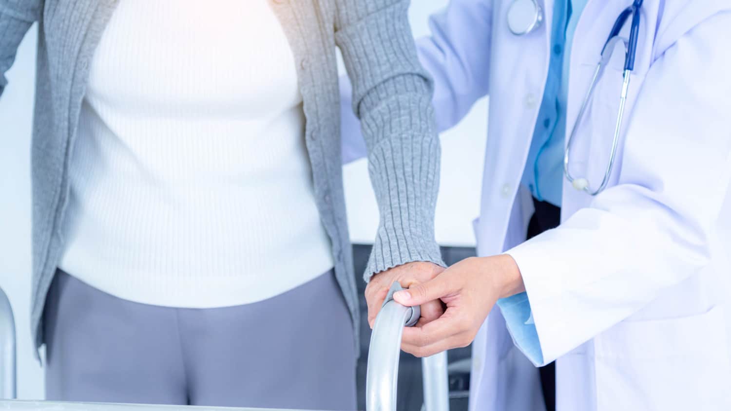 close up female doctor wearing medical mask supporting senior woman by using walker elderly patient care health care medical concept
