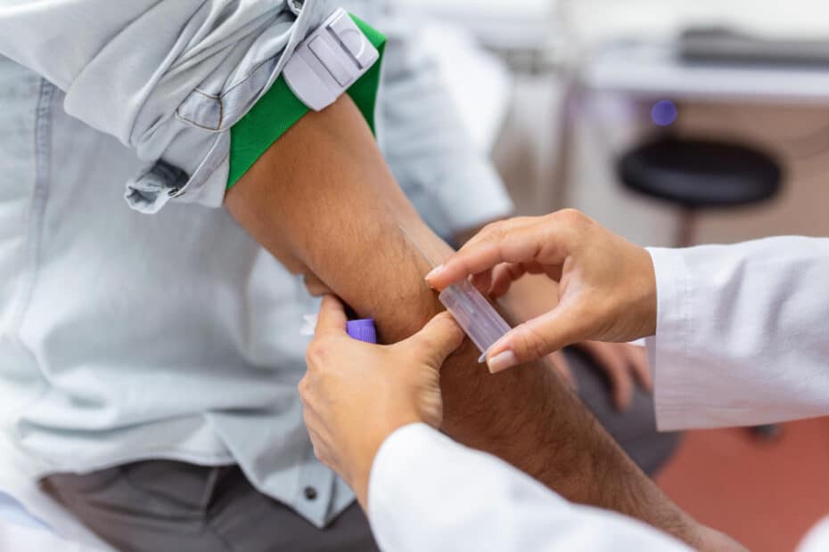 skilled focused young phlebotomy technician applying tourniquet male patient arm venipuncture
