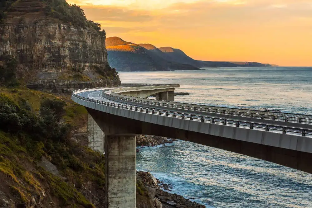 sunset sea cliff bridge along australian pacific ocean